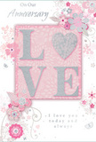 This beautifully detailed anniversary card combines refined florals and soft colour in a way that feels as personal and heartfelt as an arrangement delivered to a home near Highams Park Lake. The central focus is the word LOVE, presented in raised, softly glittered letters that catch the light with a delicate shimmer, suggestive of morning sun on fresh petals. The letters are substantial enough to be felt under the fingertips, lending a tactile richness that makes the card more than just a flat image. Surrounding this central word, fine-line illustrations of flowers and leaves sweep and curl in gentle arcs, forming a loosely circular frame. The blooms, drawn with soft shading and fine details, resemble stylised roses or garden blossoms, their forms carefully balanced to appear both intricate and airy. A background of gentle blush pink supports the design, subtly mottled and shaded to evoke layered paper or softly clouded sky. Throughout the floral pattern, accents of silver and pearly white add depth, catching glints of light like delicate threads woven through a bouquet ribbon. The text on the card, set in an elegant script, expresses enduring affection and appreciation, the kind of message couples in Highams Park might choose to mark an anniversary dinner at home after a walk along nearby woodland paths. While no real flowers are present, the composition echoes the feeling of a hand-crafted anniversary posy: romantic, tender, and imbued with quiet meaning. It is an image that suggests treasured memories, gentle promises, and the comforting sense of being deeply loved over time.